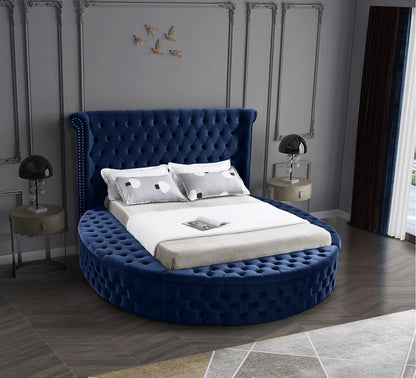 Alora round storage bed in blue velvet in a bedroom, front view