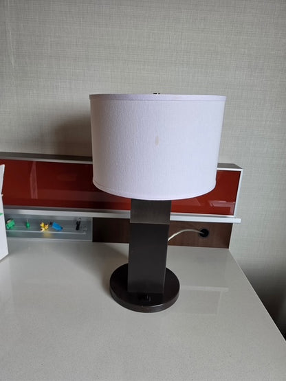 Table lamp with dark base and white drum shade
